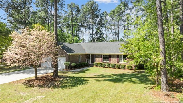 7783 Trappers Rd, Fayetteville, NC 28311 - ranch-style home with concrete driveway, a garage, and a front lawn