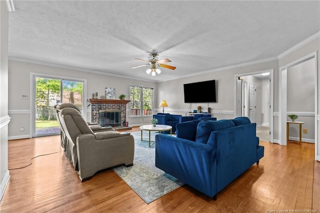 7783 Trappers Rd, Fayetteville, NC 28311 - living area with ceiling fan, a fireplace, light wood-type flooring, a textured ceiling, and ornamental molding