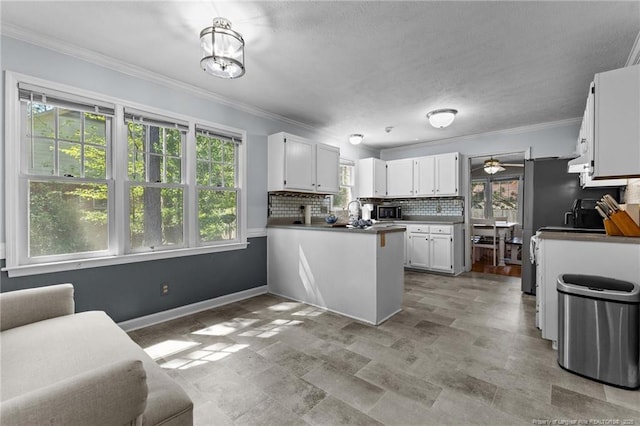 7783 Trappers Rd, Fayetteville, NC 28311 - kitchen with ornamental molding, decorative backsplash, white cabinetry, and a peninsula