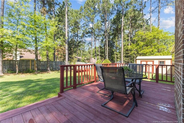 7783 Trappers Rd, Fayetteville, NC 28311 - deck with a yard, a fenced backyard, outdoor dining area, and an outdoor structure