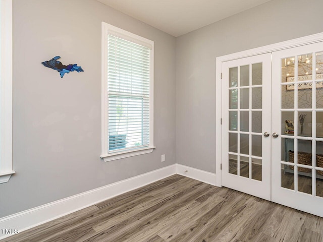 spare room with wood finished floors, baseboards, and french doors