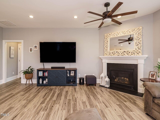 living area with ceiling fan, wood finished floors, recessed lighting, baseboards, and a fireplace with flush hearth