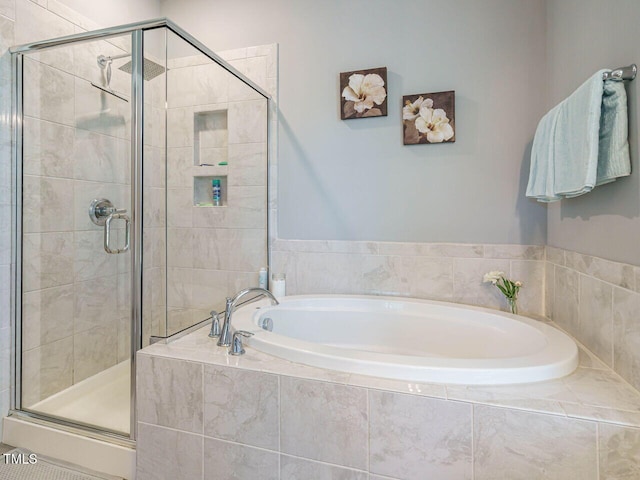 bathroom with a stall shower and a bath