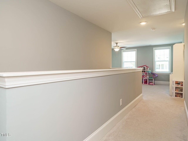 hall with attic access, baseboards, light carpet, and recessed lighting