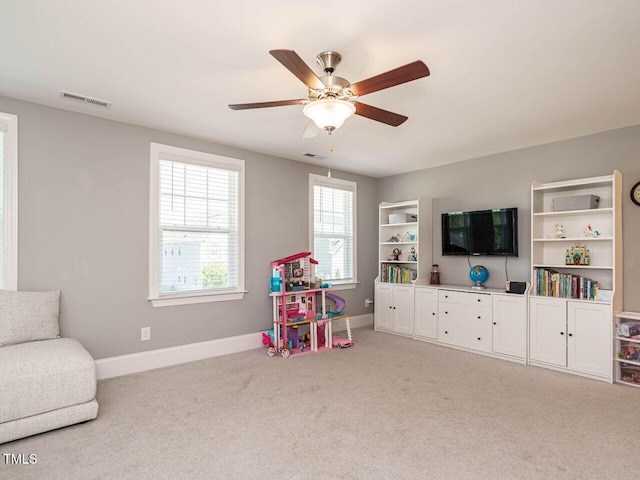 rec room with carpet floors, a ceiling fan, and baseboards