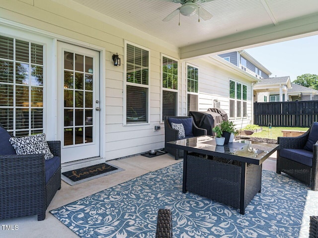 view of patio with an outdoor hangout area, fence, and ceiling fan