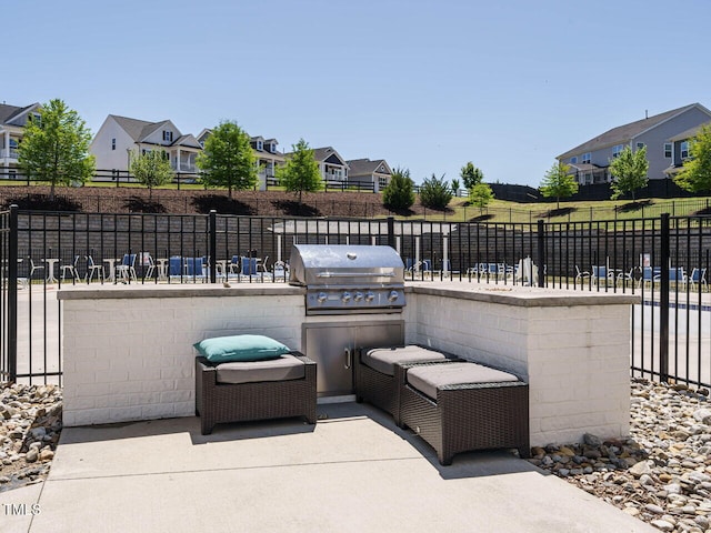 view of patio featuring a grill, a residential view, and fence