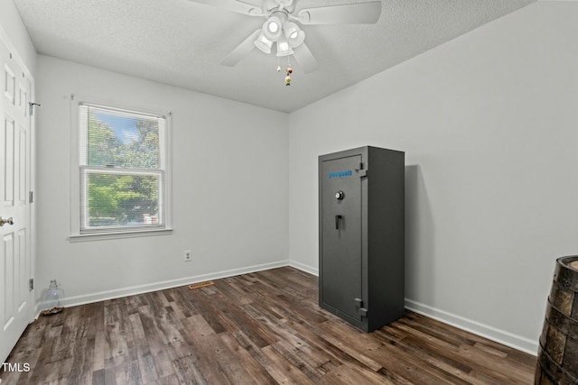 unfurnished bedroom with dark wood-style flooring, baseboards, a ceiling fan, and a textured ceiling