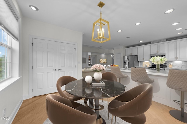 dining area featuring light wood-type flooring, a wealth of natural light, a chandelier, and recessed lighting