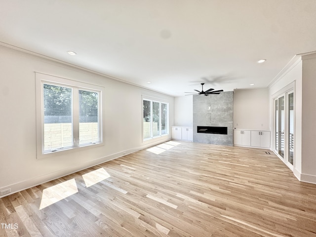 622 Glascock St, Raleigh, NC 27604 - unfurnished living room featuring ornamental molding, plenty of natural light, a tile fireplace, light wood-type flooring, and ceiling fan