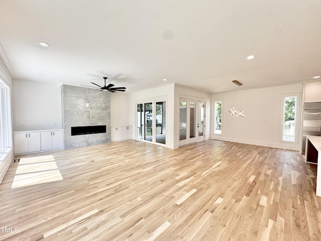 622 Glascock St, Raleigh, NC 27604 - unfurnished living room featuring crown molding, a ceiling fan, healthy amount of natural light, light wood-type flooring, and a tile fireplace