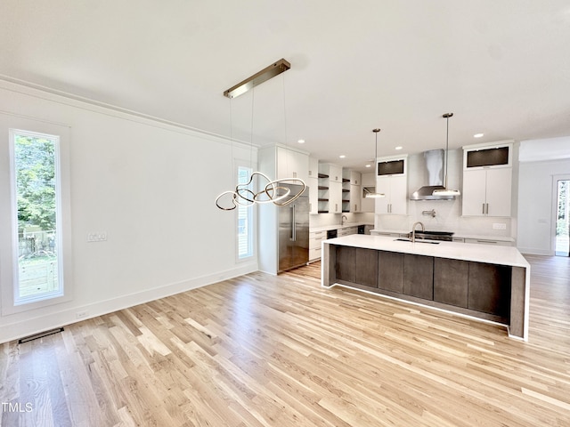 622 Glascock St, Raleigh, NC 27604 - kitchen featuring wall chimney range hood, open shelves, light countertops, light wood finished floors, and backsplash