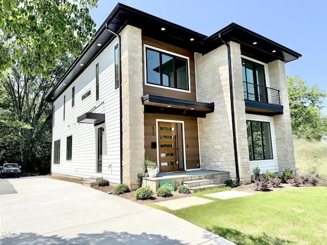 622 Glascock St, Raleigh, NC 27604 - contemporary home featuring a balcony, stone siding, a front lawn, and driveway