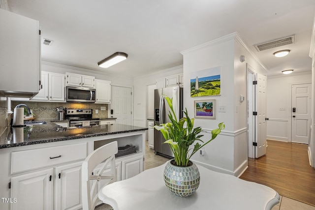 105 Cavendish Dr, Cary, NC 27513 - kitchen featuring appliances with stainless steel finishes, a sink, ornamental molding, a peninsula, and white cabinets