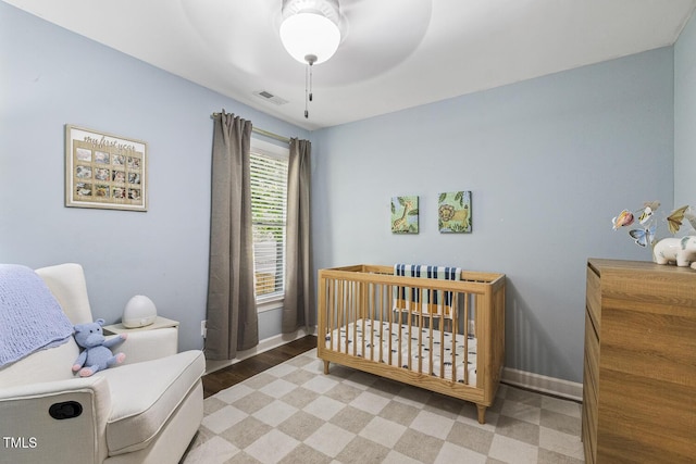 105 Cavendish Dr, Cary, NC 27513 - bedroom with a crib, baseboards, wood finished floors, and a ceiling fan