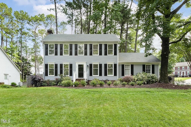 105 Cavendish Dr, Cary, NC 27513 - colonial home with a chimney, a front lawn, and roof with shingles