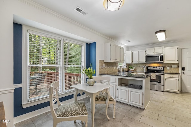 105 Cavendish Dr, Cary, NC 27513 - kitchen featuring stainless steel appliances, a peninsula, backsplash, a sink, and ornamental molding