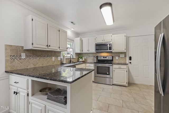 105 Cavendish Dr, Cary, NC 27513 - kitchen featuring stainless steel appliances, a sink, dark stone counters, white cabinets, and crown molding