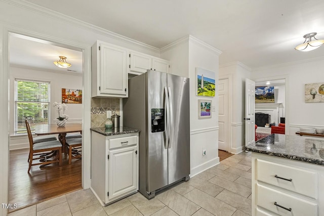 105 Cavendish Dr, Cary, NC 27513 - kitchen featuring stainless steel fridge, light tile patterned flooring, white cabinets, dark stone counters, and a brick fireplace