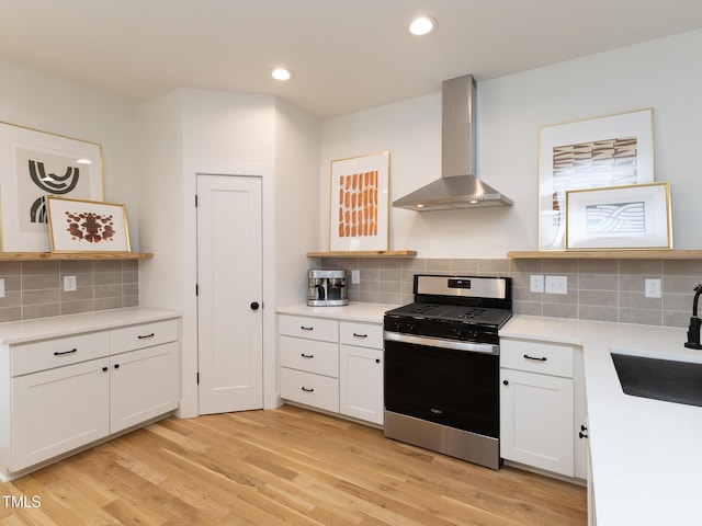 612 E Ellerbee St, Durham, NC 27704 - kitchen with gas range, wall chimney exhaust hood, a sink, backsplash, and light wood-style floors