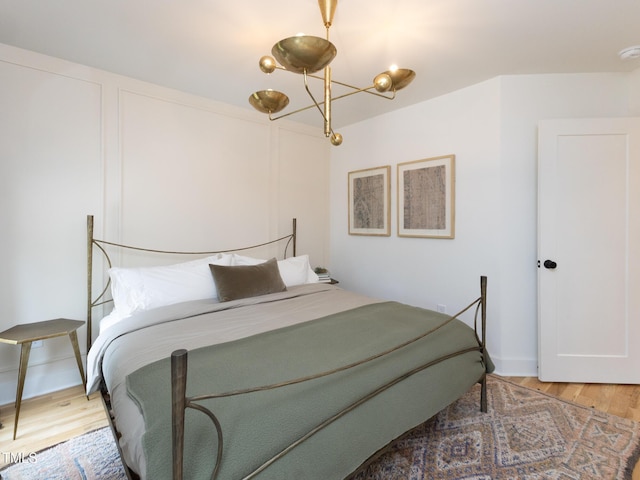 612 E Ellerbee St, Durham, NC 27704 - bedroom featuring light wood finished floors and a chandelier