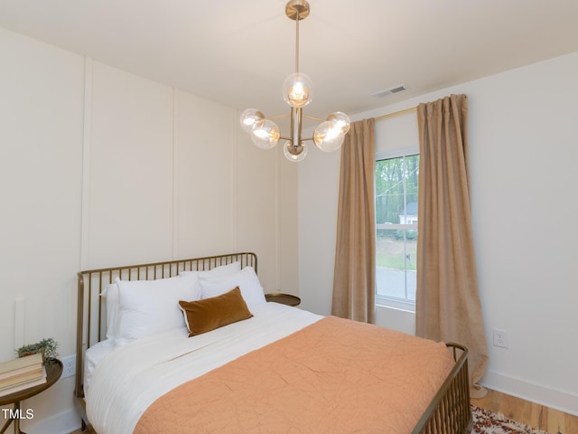 612 E Ellerbee St, Durham, NC 27704 - bedroom with light wood-type flooring and a chandelier