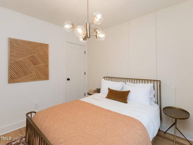 612 E Ellerbee St, Durham, NC 27704 - bedroom featuring light wood-style flooring, a chandelier, and baseboards