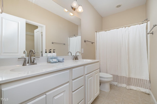 bathroom featuring tile patterned flooring, toilet, and double vanity
