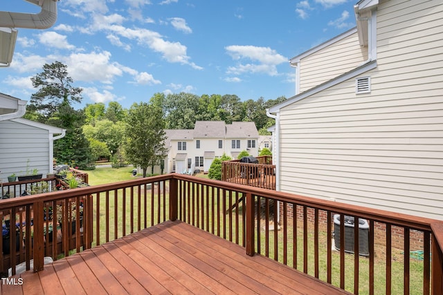 wooden terrace featuring a yard and a residential view
