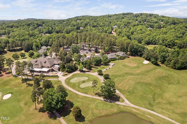 drone / aerial view with a water view, a view of trees, and view of golf course
