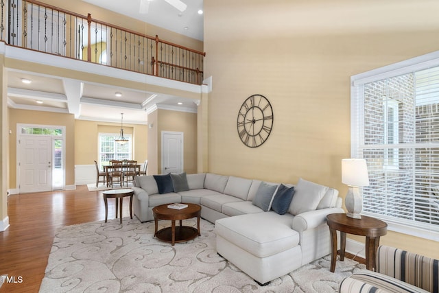 living room with crown molding, wood finished floors, baseboards, radiator heating unit, and recessed lighting