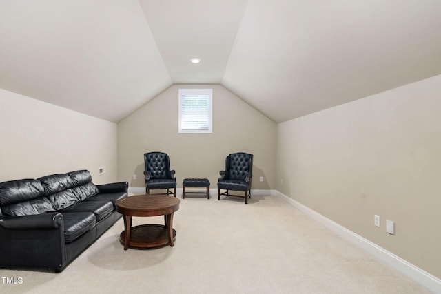 living area featuring baseboards, light carpet, and lofted ceiling