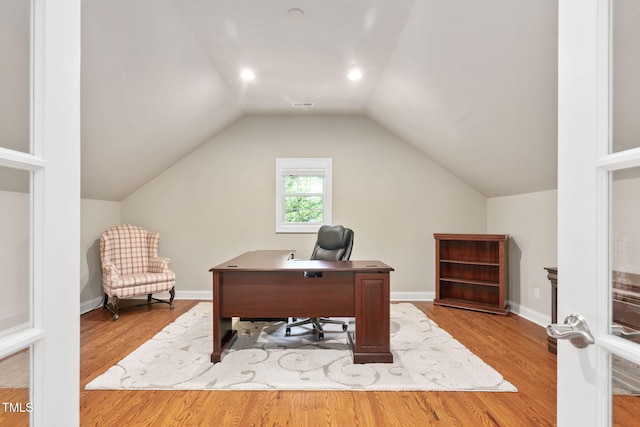 office space featuring baseboards, wood finished floors, and lofted ceiling