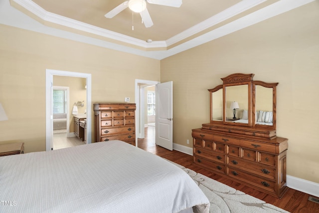 bedroom featuring a ceiling fan, baseboards, wood finished floors, visible vents, and ornamental molding