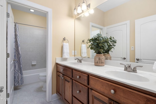 bathroom with a sink, tile patterned flooring, toilet, and double vanity