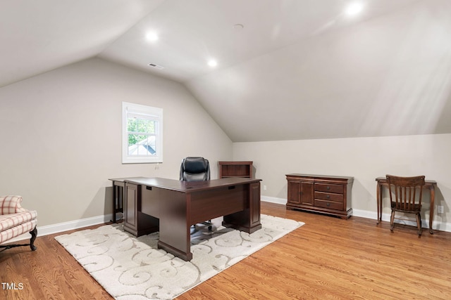 office space featuring visible vents, light wood-type flooring, baseboards, lofted ceiling, and recessed lighting