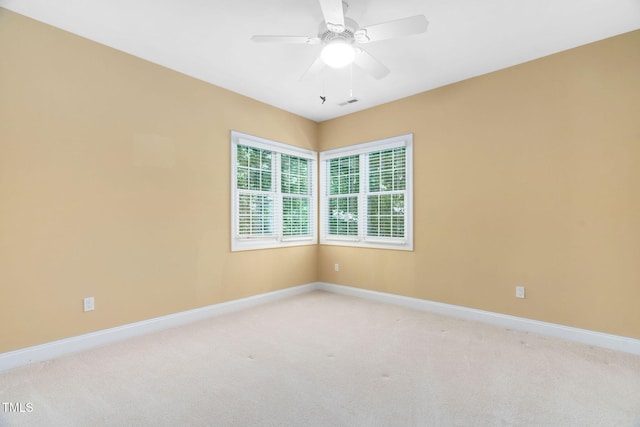 unfurnished room featuring baseboards, light colored carpet, ceiling fan, and visible vents