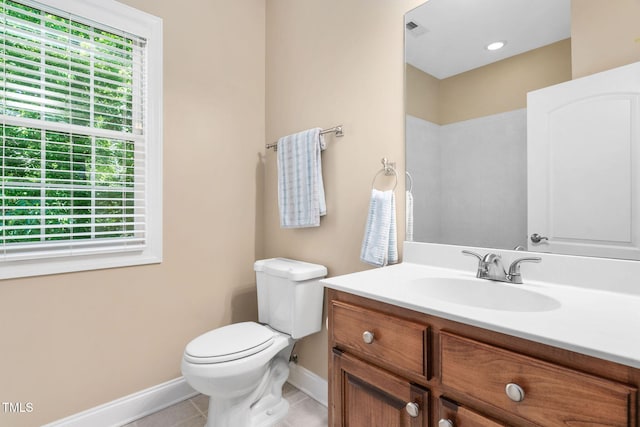 bathroom featuring baseboards, tile patterned floors, toilet, and vanity