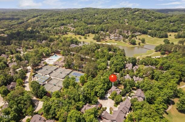 drone / aerial view with a water view and a forest view