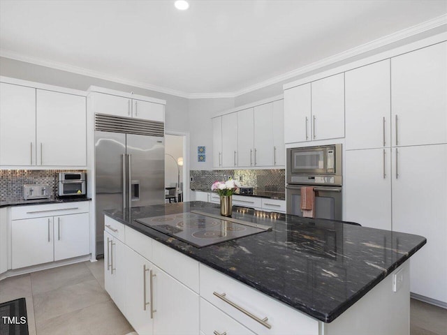 kitchen with built in appliances, tasteful backsplash, a center island, and white cabinets