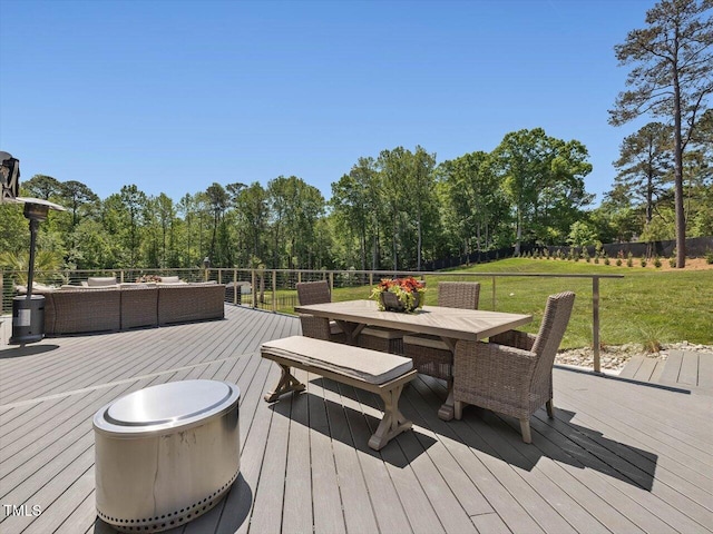 deck with a lawn, fence, outdoor dining space, and an outdoor hangout area