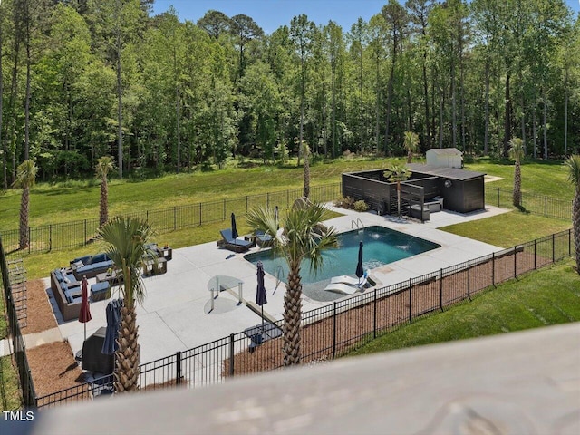 view of swimming pool featuring a patio, fence, a yard, and a fenced in pool
