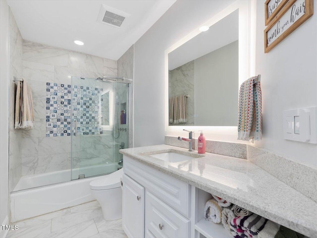 full bathroom with visible vents, vanity, marble finish floor, toilet, and bath / shower combo with glass door