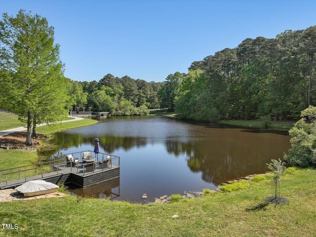 dock area featuring a water view and a wooded view