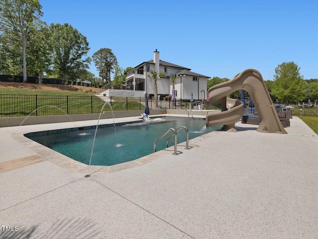 view of pool with a patio, a water slide, a fenced in pool, and fence