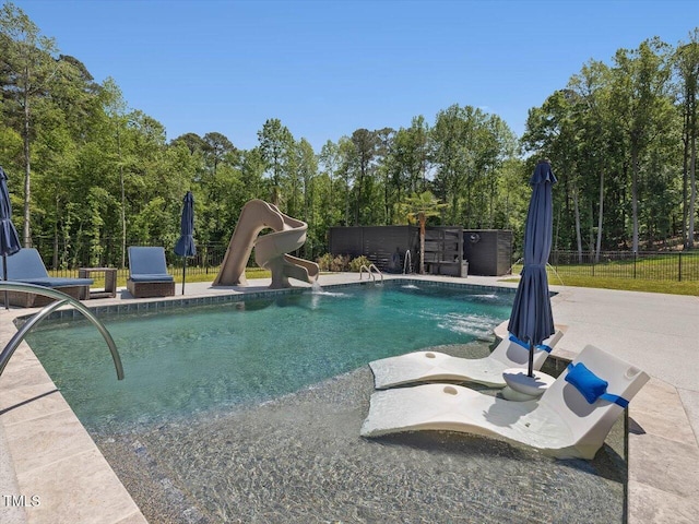 view of pool featuring fence, a water slide, a fenced in pool, and a patio