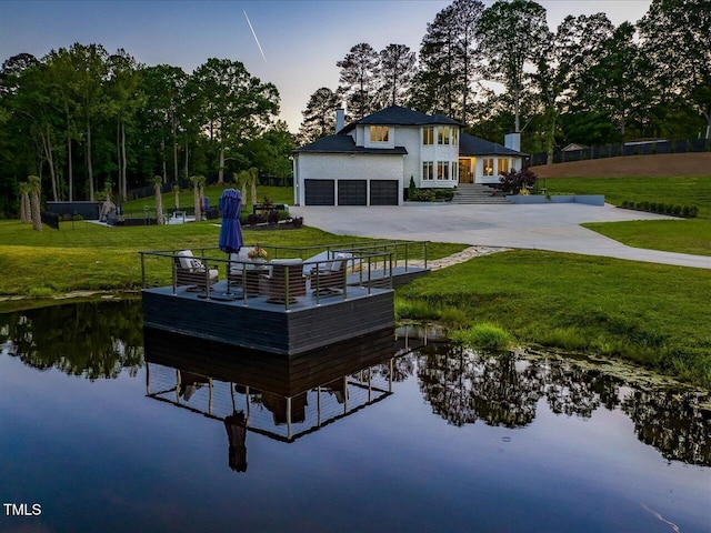 dock area with a water view and a yard