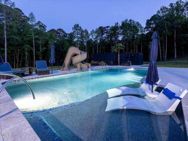 view of pool with a fenced in pool, a water slide, and fence