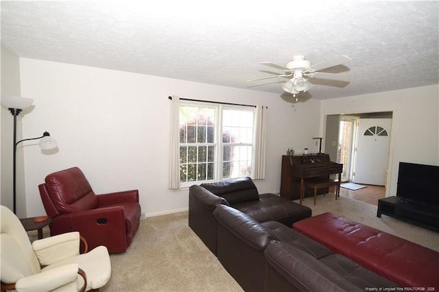 living area with a textured ceiling, a ceiling fan, and carpet floors