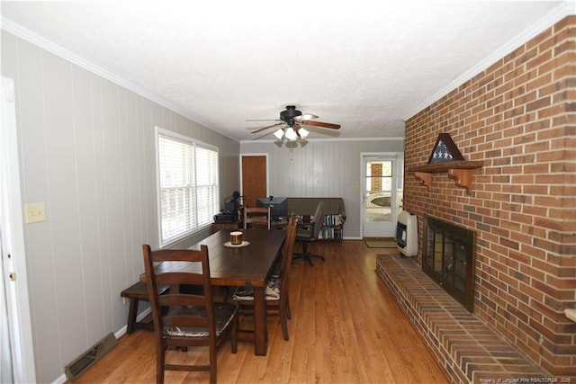 dining room with visible vents, ornamental molding, ceiling fan, and light wood-style floors